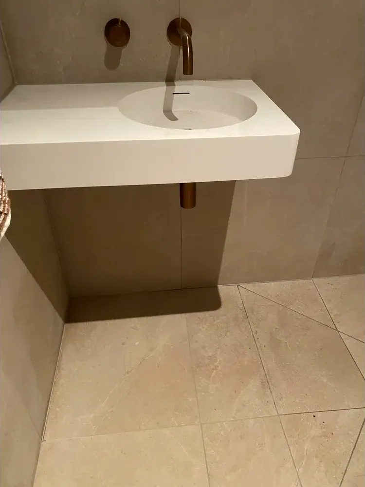Bronze tap and white basin in luxury bathroom