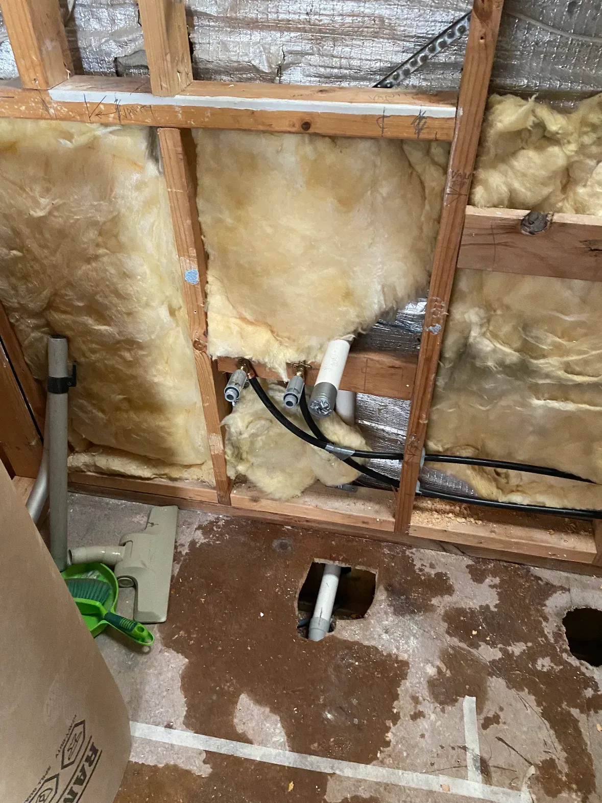 Bathroom rough-in with copper and PEX pipework framed up before lining